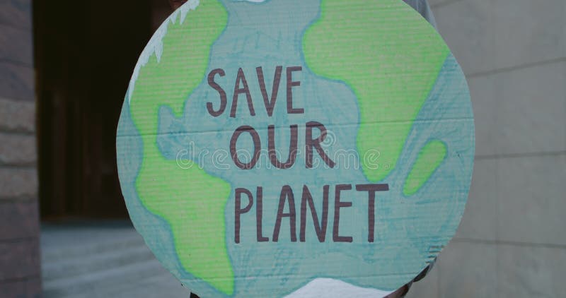 Close up view of african american person holding Earth model with writing save our planet. Male hands holding placard