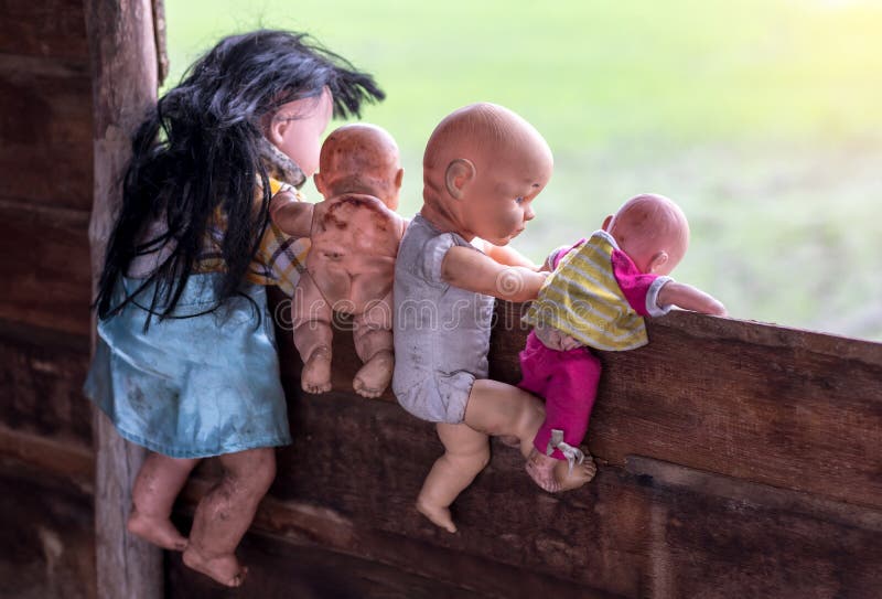 Behind old baby dolls climbing on wooden wall.