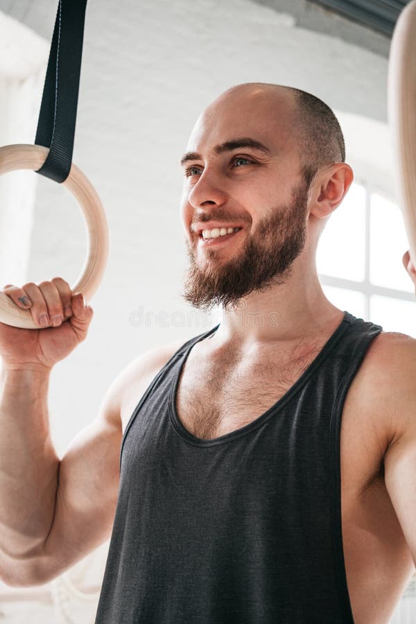 Close up view of bearded fit sportsman holding gymnastic rings at cross gym stock photos Close up view of bearded fit sportsman holding gymnastic rings at cross gym stock photos
