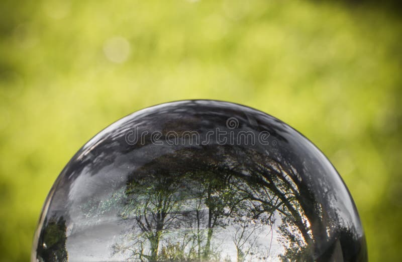 Close up view on beautiful landscape trees in blue sky and green meadow through lens ball sphere, france royalty free stock photography Close up view on beautiful landscape trees in blue sky and green meadow through lens ball sphere, france royalty free stock photography