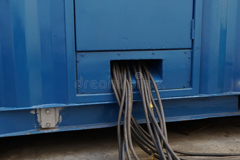 Close Up View on Bundle of Black Cables Come Out from Blue Power Pack or Portable Generator