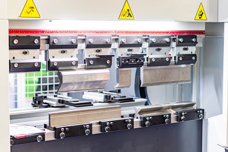 Close-up view of a CNC machine, with metallic components, bolts, levers, and warning signs Artificial lighting illuminates the machine with shadows creating depth. Elegant lighting signs stock images, royalty-free photos and pictures