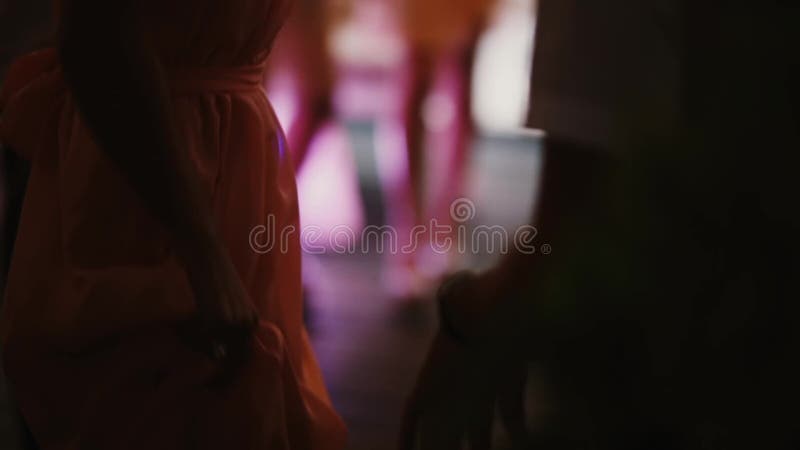 Close-up view of crowd dancing at night club. Group of people in dress and costumes have fun. Prom ball of students.