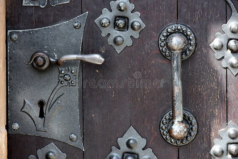 Close up view on detail of a old massive wooden door with metal shackles