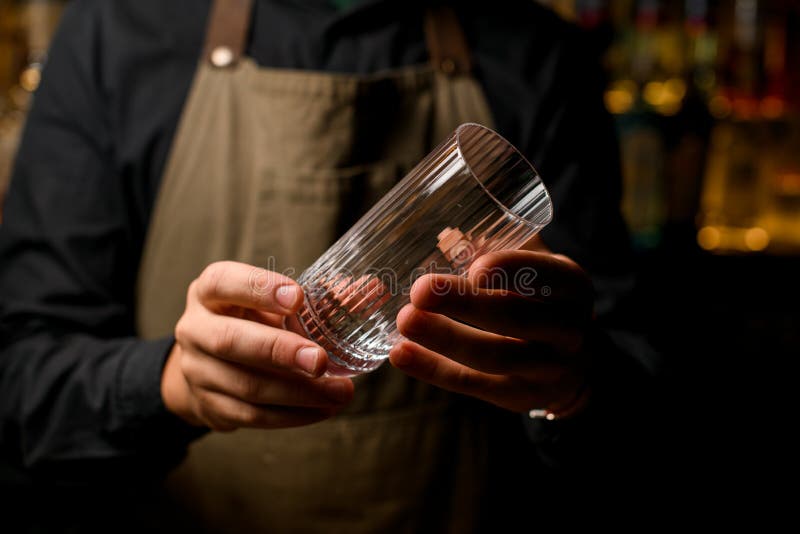 Two tall cocktail glasses half full of ice and metal jiggers on the bar  counter Stock Photo by ©Fesenko 336646890