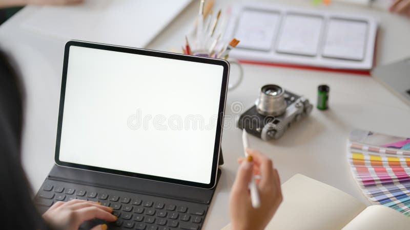 Close up view of female application developer working on blank screen tablet in co working space royalty free stock photo