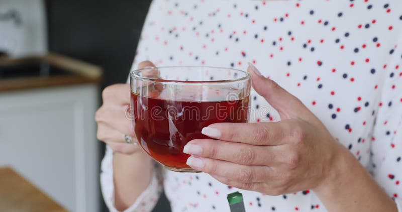 Close up view female hands holding cup with hot tea stock video footage