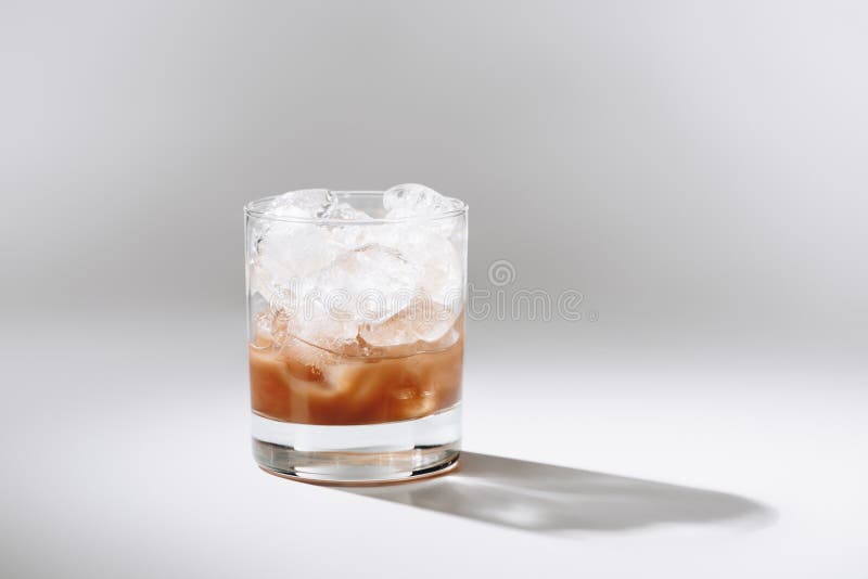 Close up view of glass of cold brewed coffee with ice cubes on white tabletop stock image