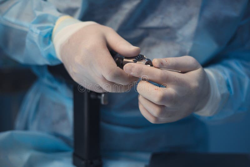 Close-up view of gloved hands meticulously preparing surgical instruments, emphasizing the precision and care essential stock image