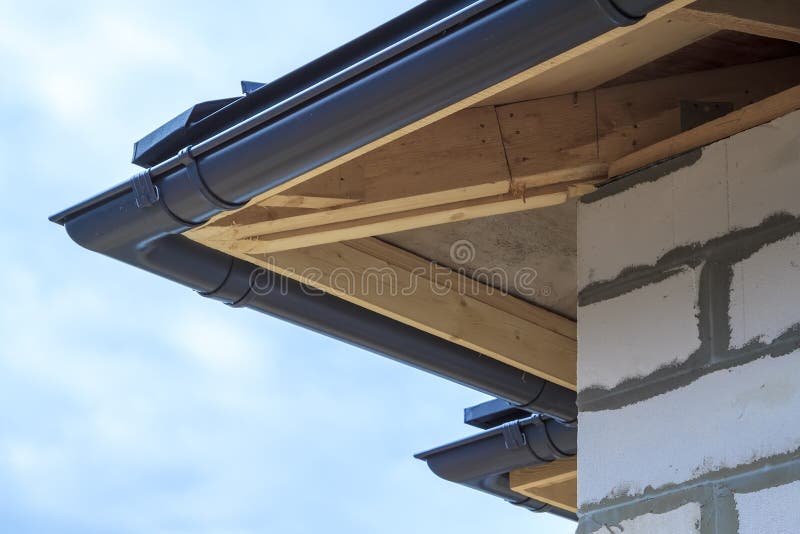 close up view of house under construction with holders for gutters water drainage system
