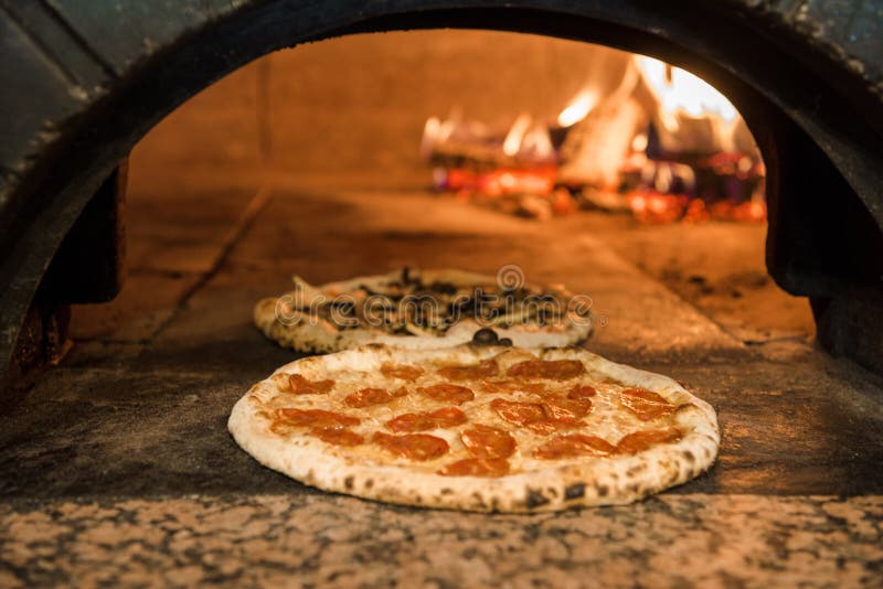 Close up view of italian pizza baking in brick oven