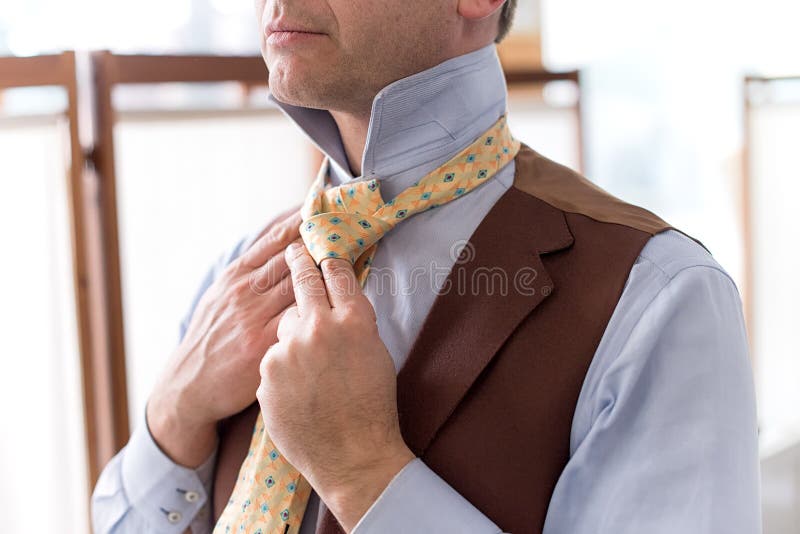 Close up view of man tieing tie