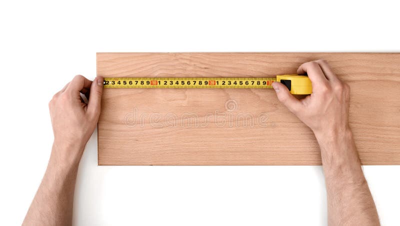 Close up view of man s hands measuring wooden plank with tape line