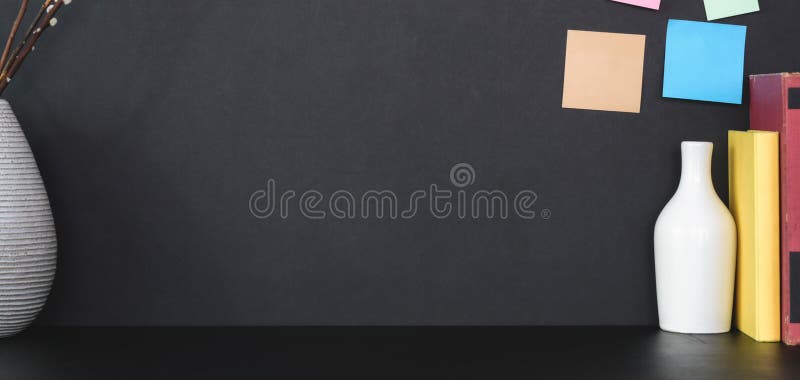 Close-up view of modern workplace with office supplies and sticky note on black table with black wall background stock images