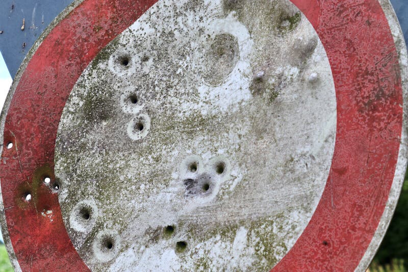 Close up view at multiple bullet holes in a german traffic sign on a countryroad royalty free stock photography Close up view at multiple bullet holes in a german traffic sign on a countryroad royalty free stock photography