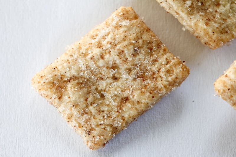 Close-up view of a piece of golden-brown, crystallized baked good with cinamon and sugar. Macro. royalty free stock images