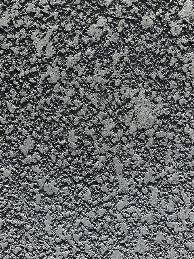 Rough concrete texture. Close-up view of a rough concrete surface displaying a complex pattern of gray and black flecks, creating a natural, textured appearance often used in architectural and industrial design