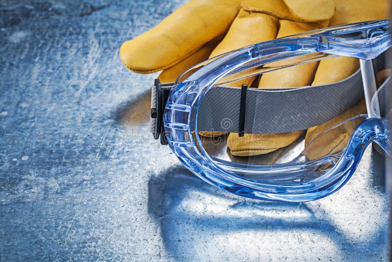 Close Up View of Safety Glasses Gloves on Metallic Background Stock