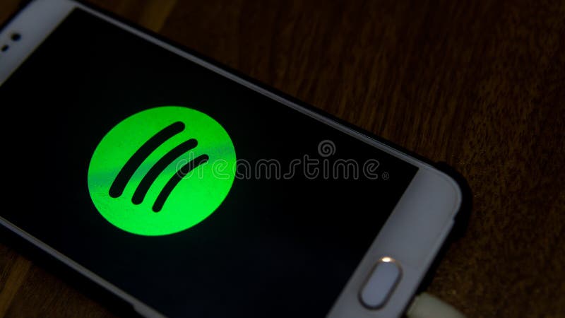 The close up view of the Spotify logo display on an Android phone with wooden table background stock image