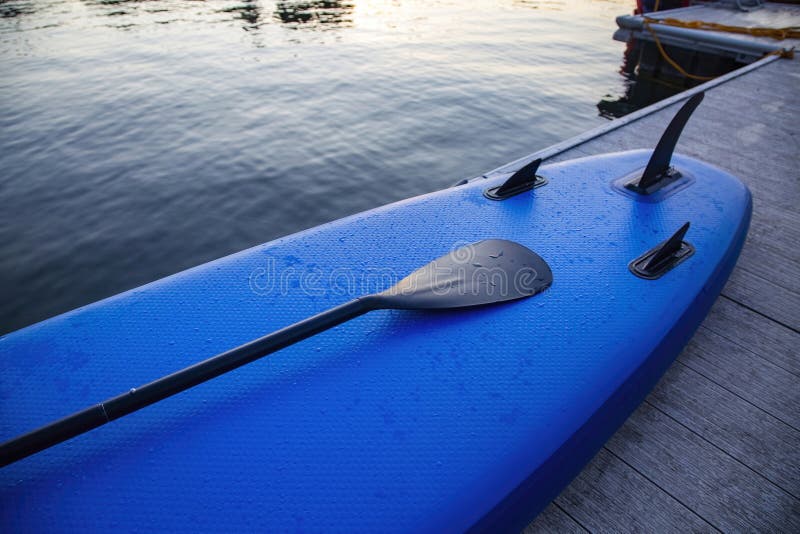 Close up view of a stand up paddle sitting on the edge of the lake stock photos