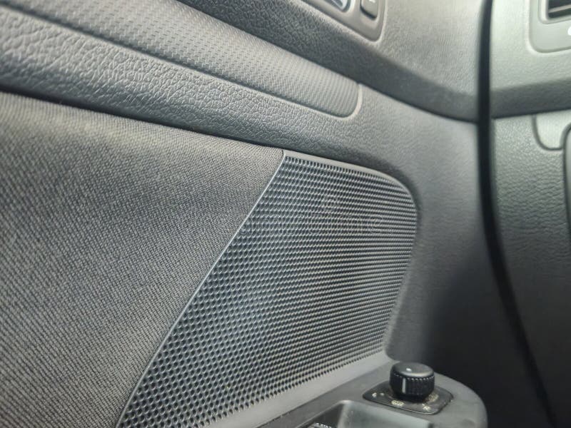 Close-up view of a textured car interior, showcasing a speaker and controls, emphasizing design and functionality for au stock photography