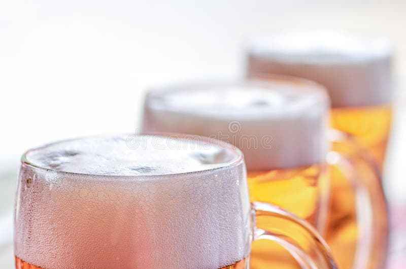 Closeup View of Three Glasses of Chilled Beer with White Foam Stock