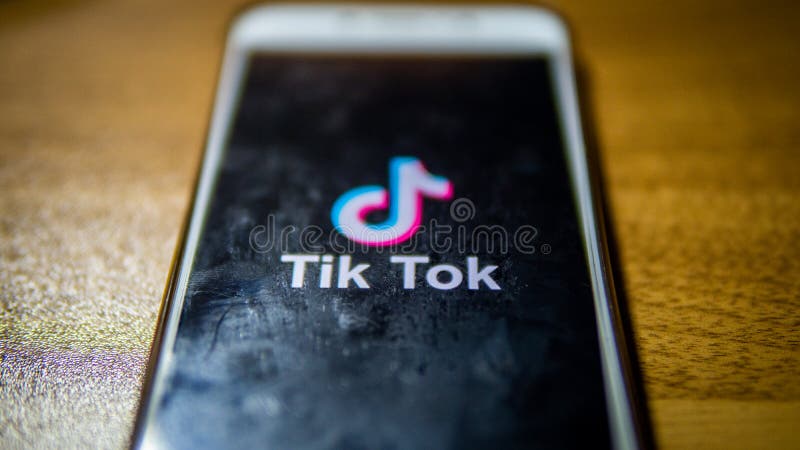 Close up view of the Tik Tok logo on an android smartphone with wooden table background stock photo
