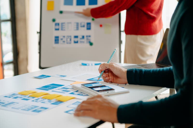 Close up view of UI developer team brainstorming on their project with laptop, smartphone and digital tablet. Creative digital stock image
