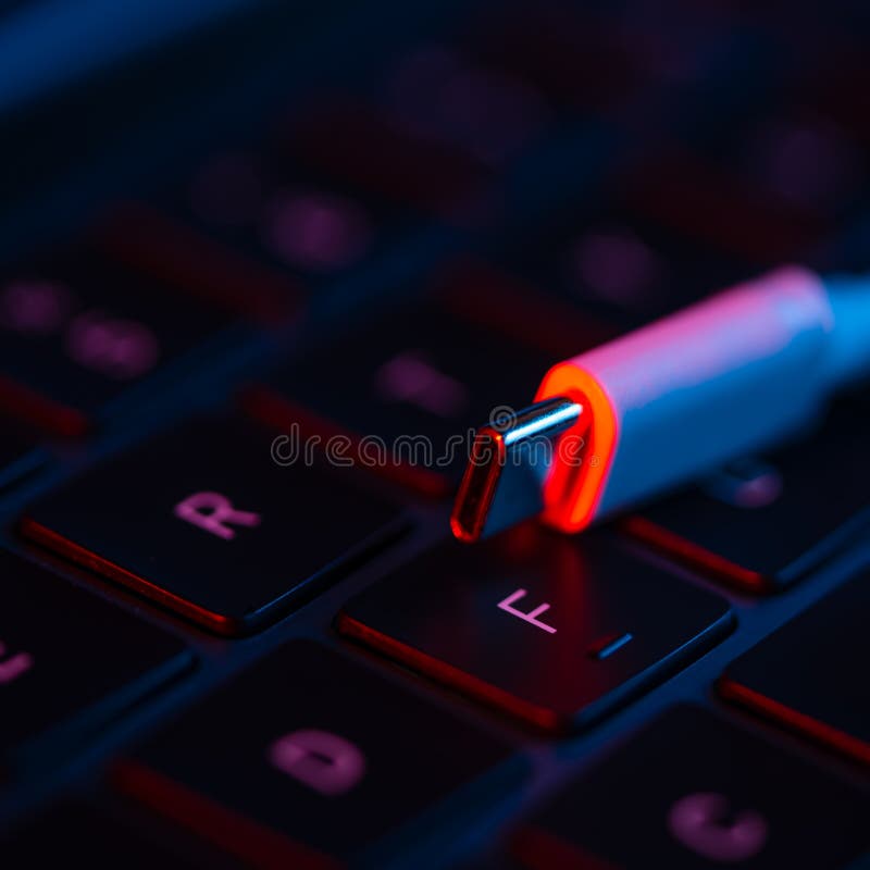 Close-up view of USB switch on a laptop keyboard with neon lights. Concept of modern technology. Computer equipment. Charger.