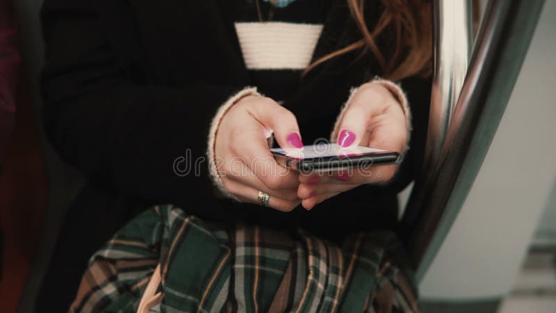Close-up view of woman s hand holding a smartphone, sitting in public transport. Girl uses touchscreen technology. royalty free stock photo Close-up view of woman s hand holding a smartphone, sitting in public transport. Girl uses touchscreen technology. royalty free stock photo