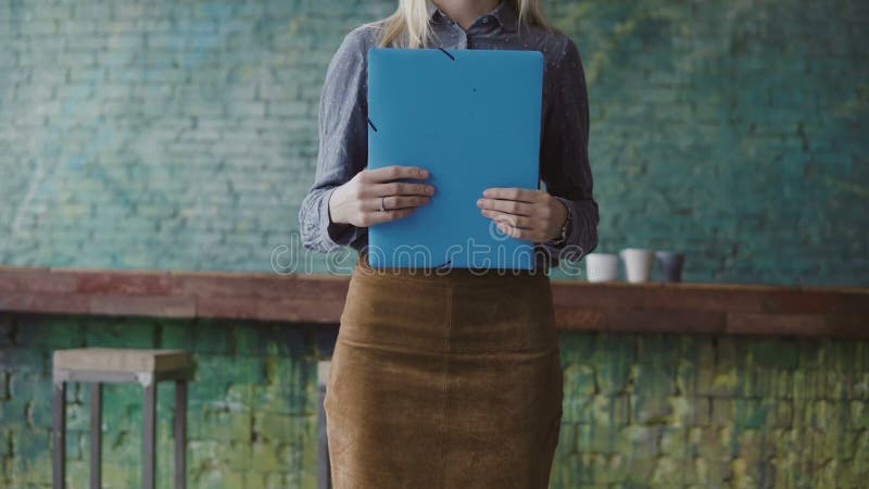 Close-up view of young blonde female holding the documents. Woman manager working in modern trendy office. royalty free stock images Close-up view of young blonde female holding the documents. Woman manager working in modern trendy office. royalty free stock images