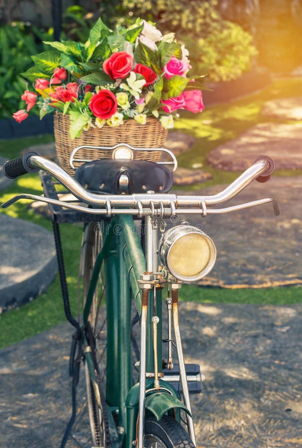 Close up vintage bicycle with bouquet flowers in basket