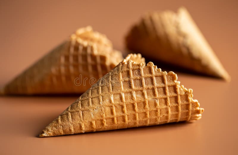 Waffle cone with heart-shaped marshmallows, close-up on a blue