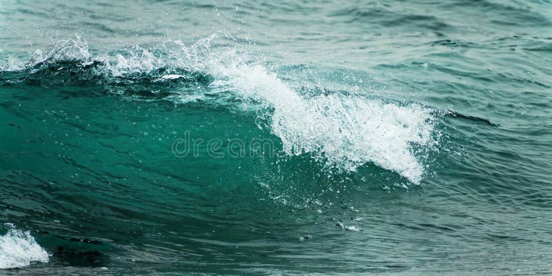 Close up of a wave. Blue clear water splash ocean background