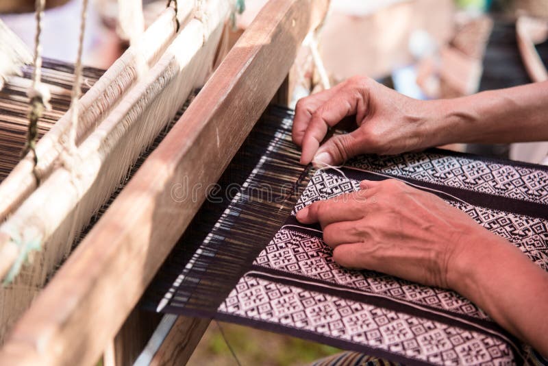 Close Up Weavers are Weaving with a Loom and Threading. Stock Photo