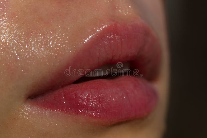 Close-up of wet nature lips. Lips with gloss makeup. Filler Injections, Plastic Surgery, Collagen and Treatments.