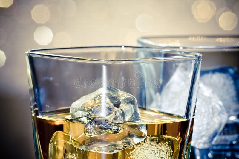 Close-up of whiskey glasses on blue light and bokeh background. Bokeh whiskey stock images, royalty-free photos and pictures