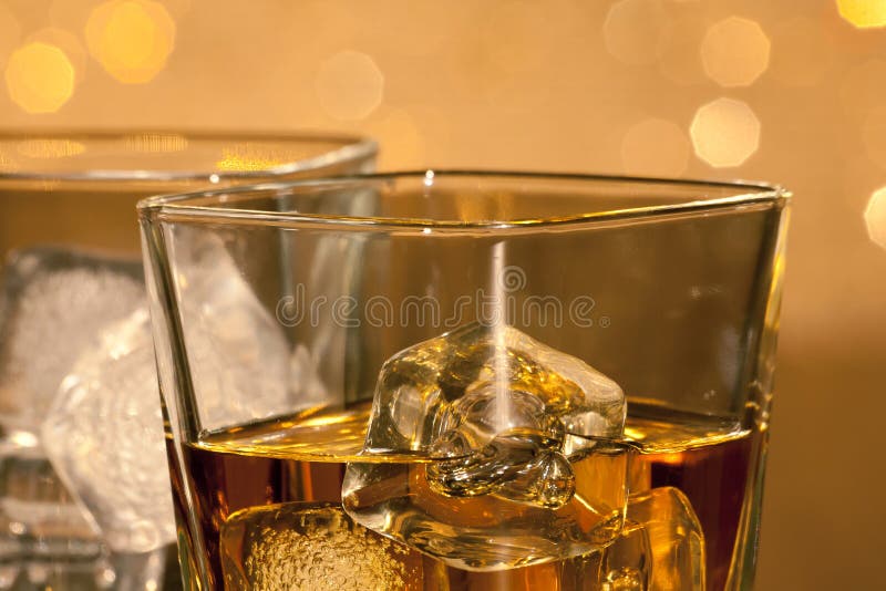 Close-up of whiskey glasses on gold bokeh background. Bokeh whiskey stock images, royalty-free photos and pictures
