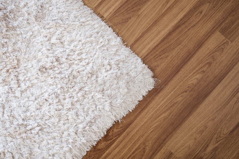 Close-up white carpet on laminate wood floor in living room , interior decoration