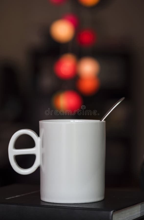 Close up white coffee cup on the book and colorful blur light bo stock photos Close up white coffee cup on the book and colorful blur light bo stock photos