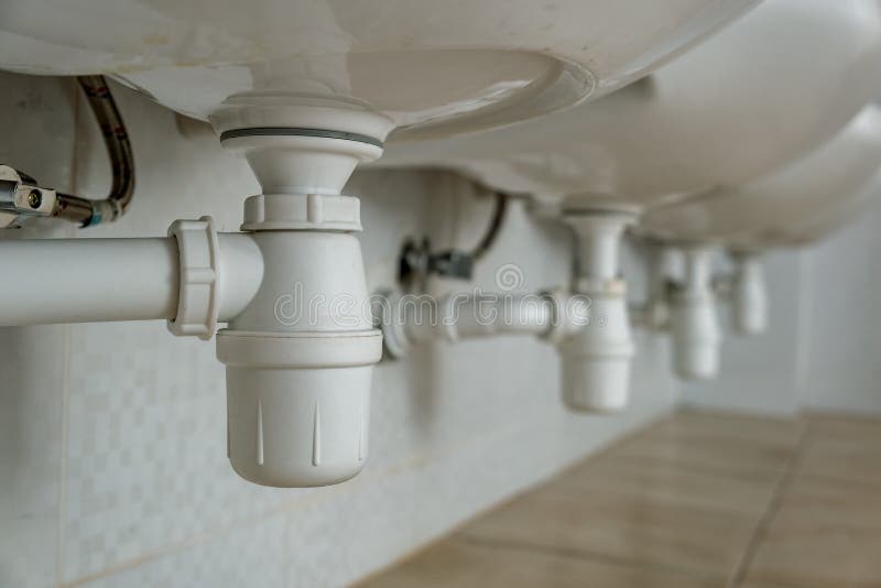 Close Up of White Plastic Pipe Drain Under Washing Sink in Bathroom