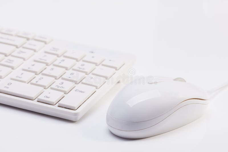 Close up of white wireless keyboard and wired mouse with shallow depth of field