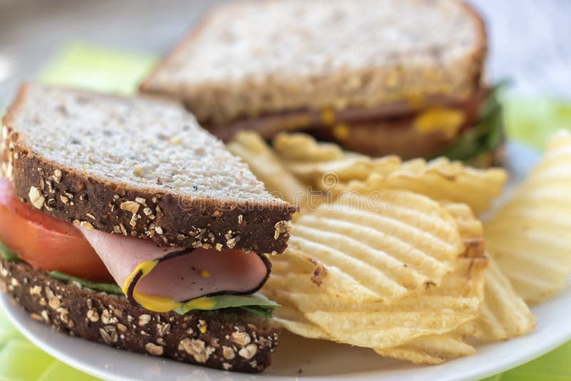 Close Up of Whole Wheat Sandwich with Potato Chips on Side Stock Photo