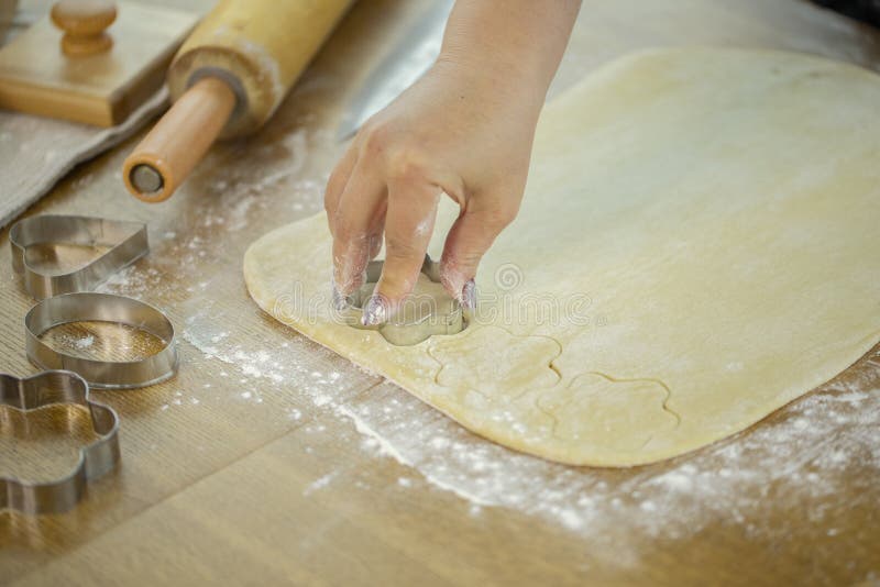 Close up woman baking handmade sugar cookies flower shape. Holiday season baking