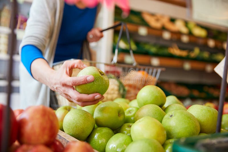 Close Up Of Woman Customer With Basket Buying Fresh Apples In Organic Farm Shop