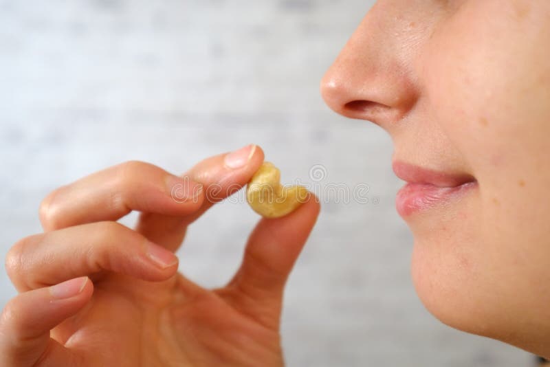 Close-up of woman eating cashew nuts stock images