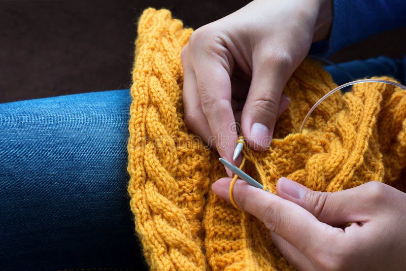 Close up of woman hands knitting colorful wool yarn