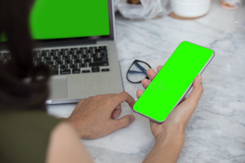 Close up woman hands using smartphone and laptop