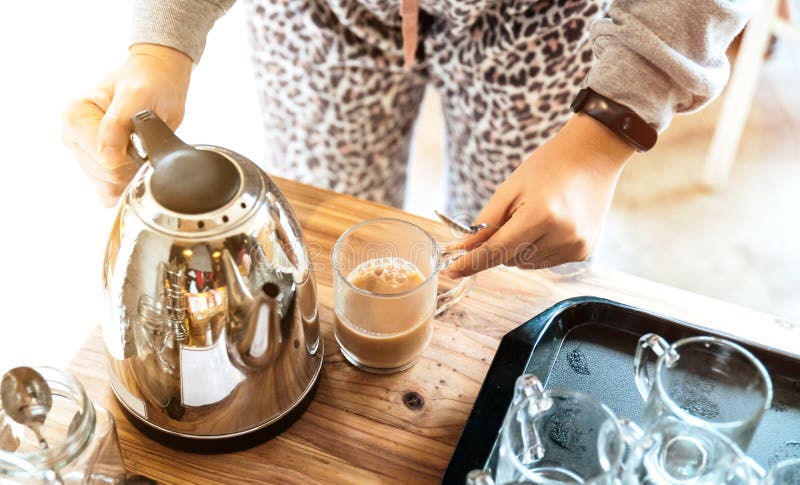 Close-up top above view woman hand hold steel thermos pouring hot