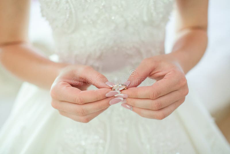 Close up of woman`s hand holding elegant diamond ring with feather and gray Scarf background. Diamond ring. stock photography Close up of woman`s hand holding elegant diamond ring with feather and gray Scarf background. Diamond ring. stock photography